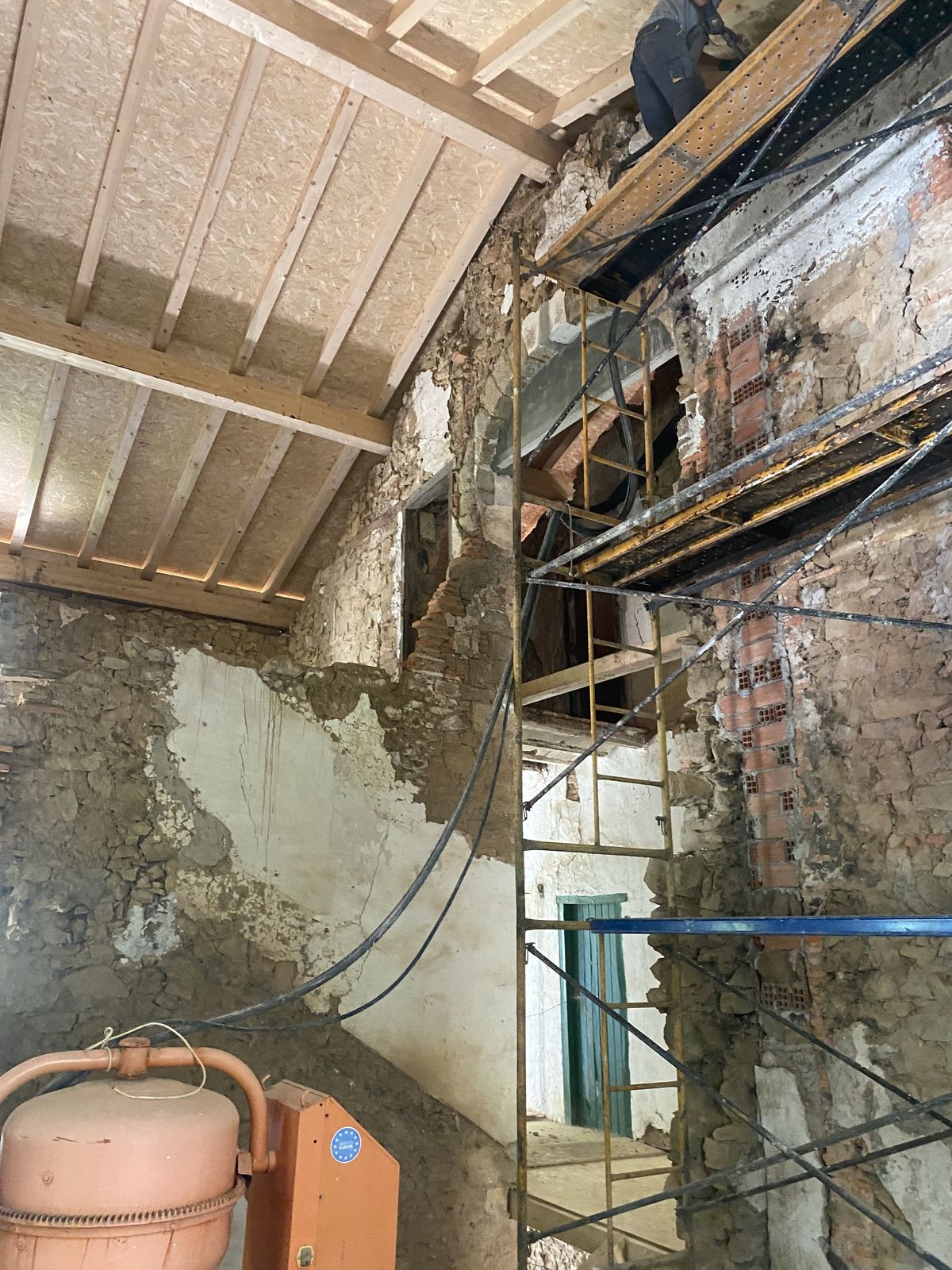 Estructura de andamios durante la rehabilitación de muro de piedra