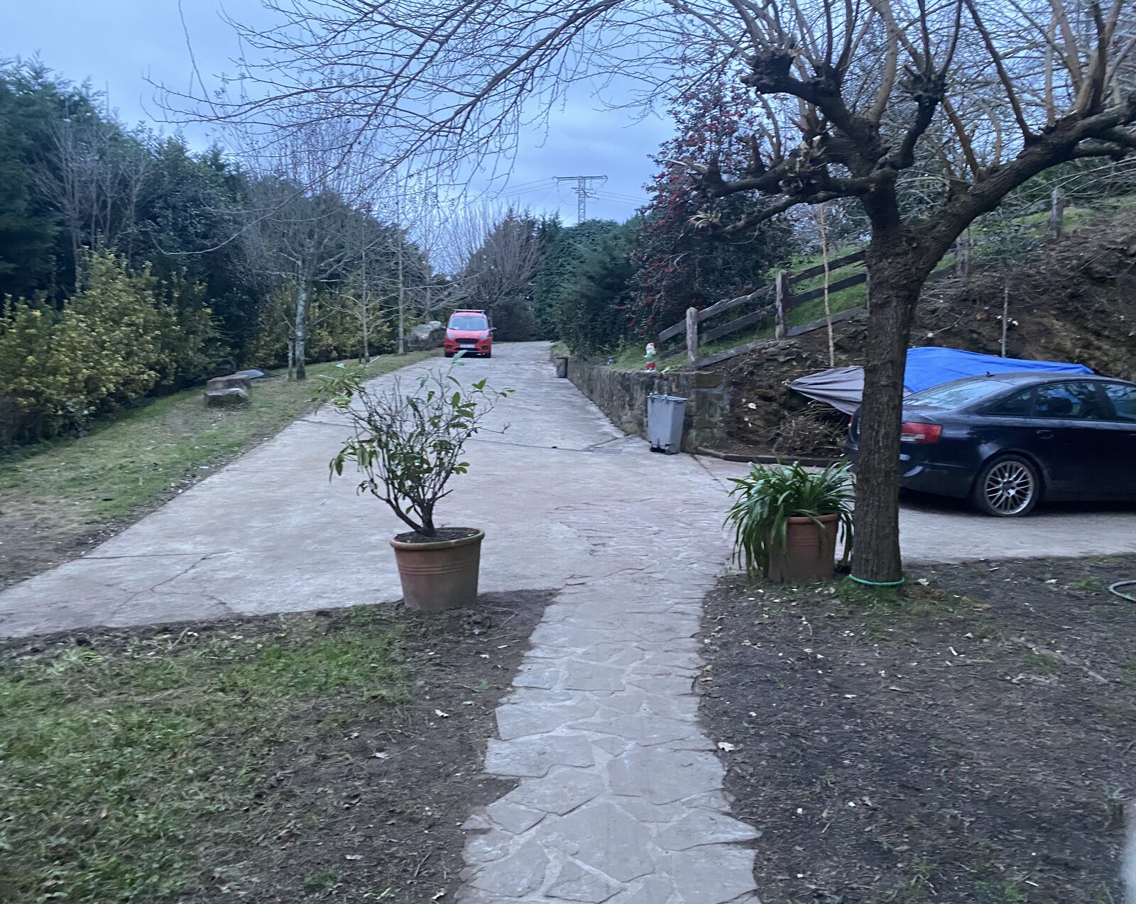 Camino despejado con vehículo protegido junto al muro de piedra